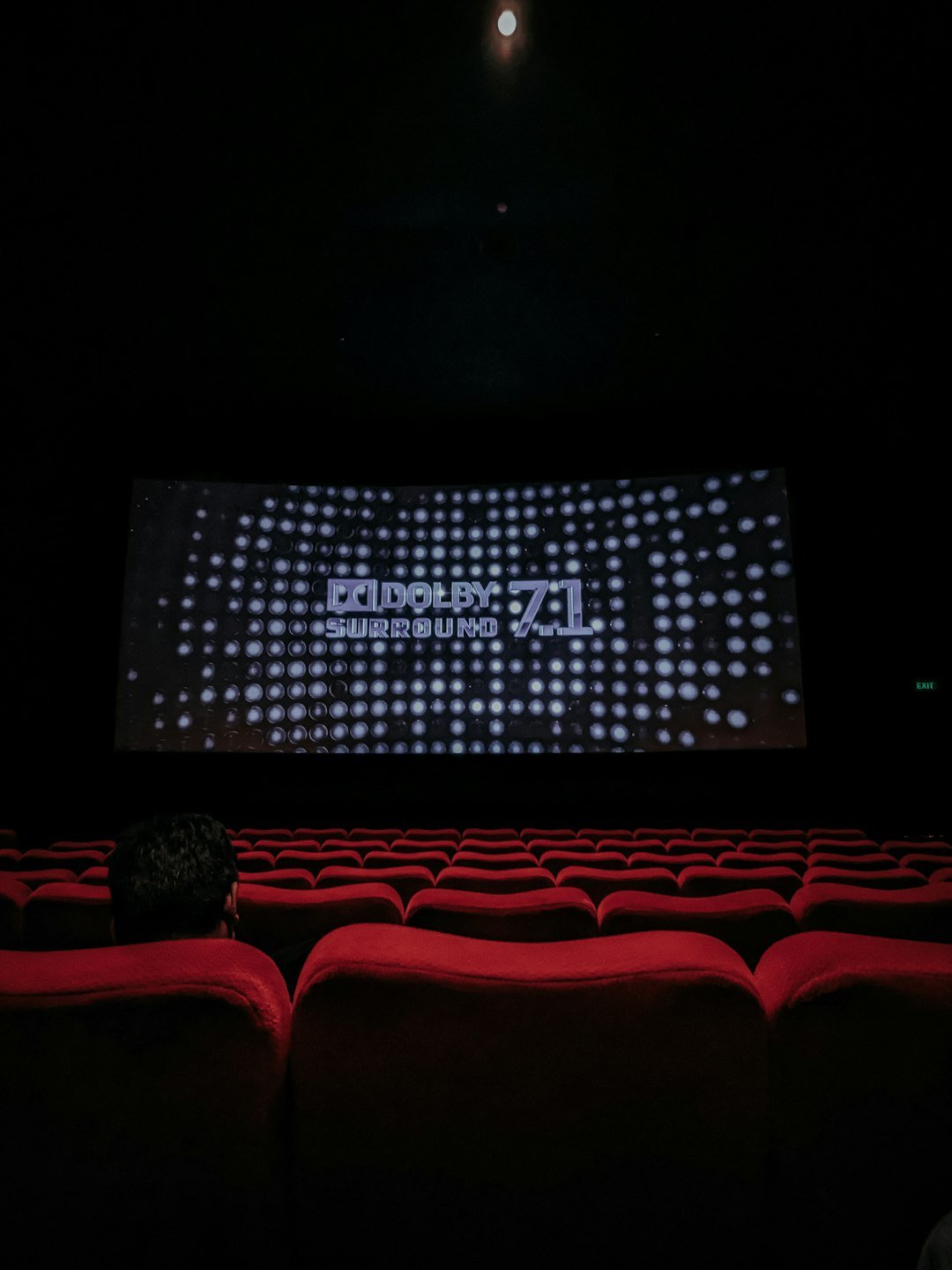 an-empty-theater-with-a-large-screen-on-the-wall-hnmyxsh5g9q